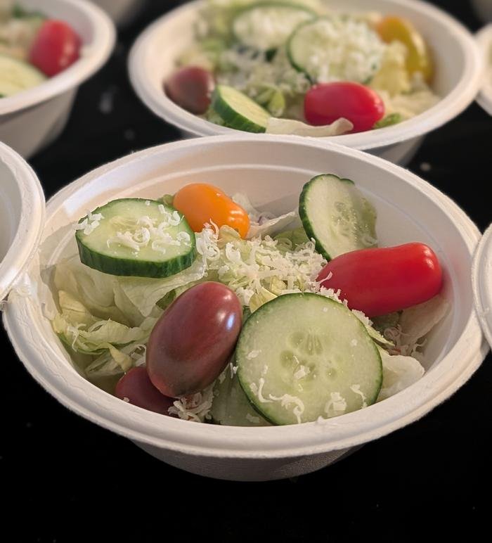 Individual salad cups topped with cucumber, tomato and shredded cheese